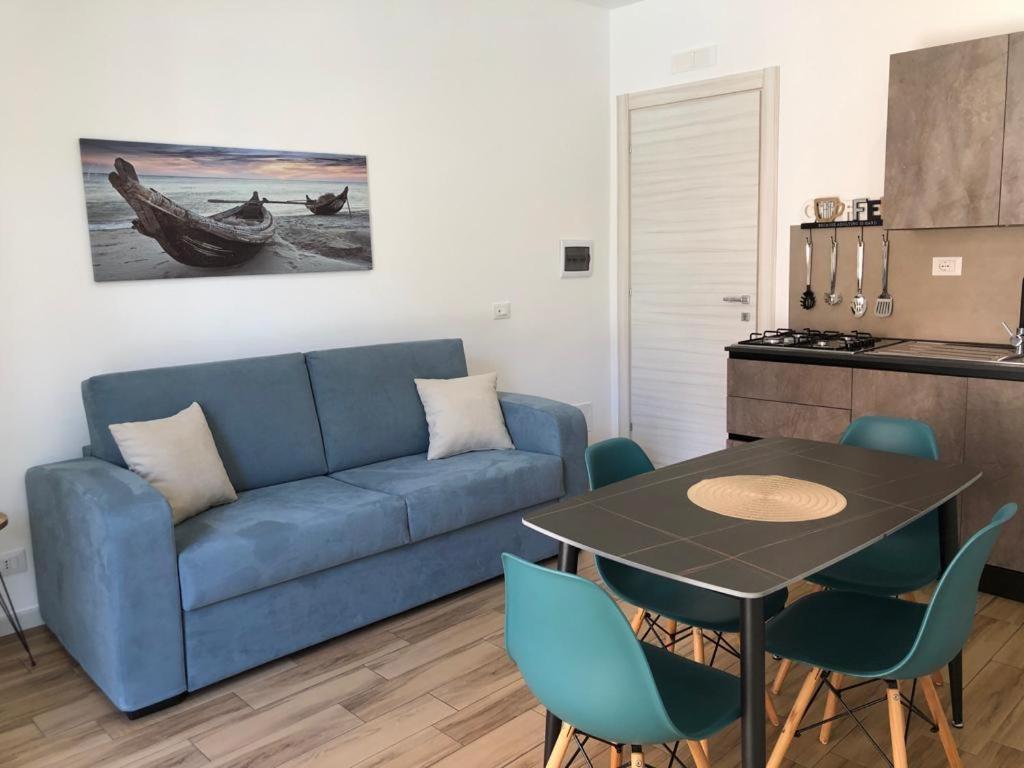 uma sala de estar com um sofá azul e uma mesa em Charme Apartments em Trapani