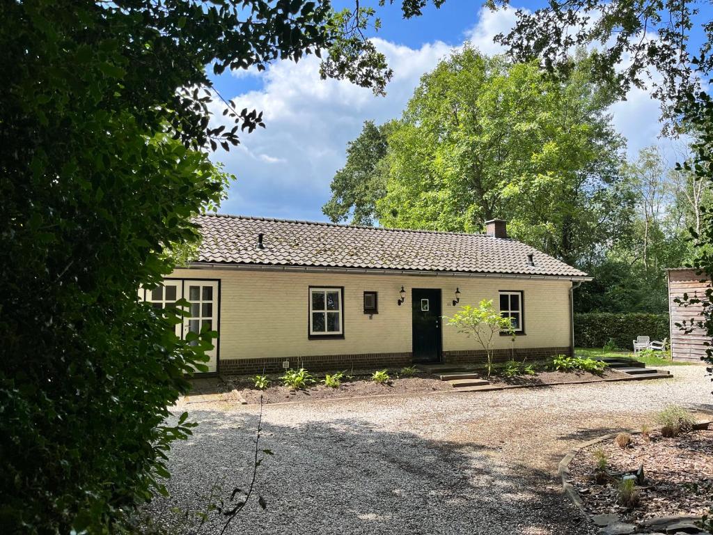 een wit huis met een zwarte deur bij Guesthouse 't Oeyenbos in Knegsel