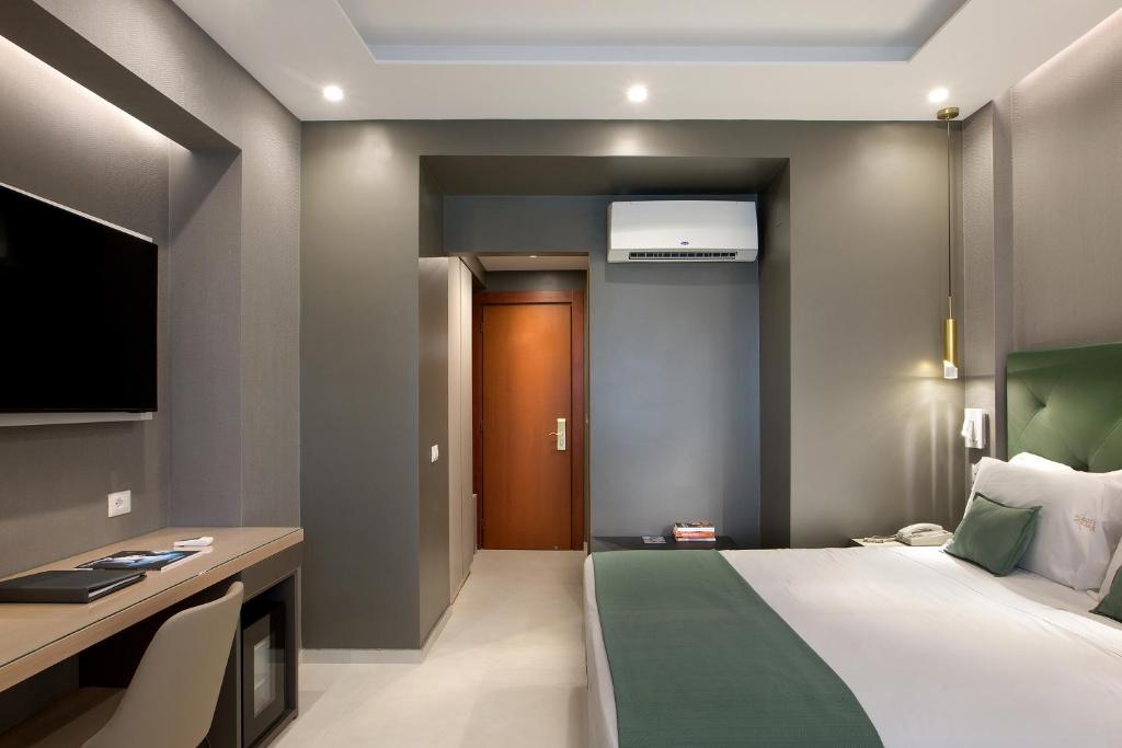 a bedroom with a bed and a desk and a television at Montespina Park Hotel in Naples