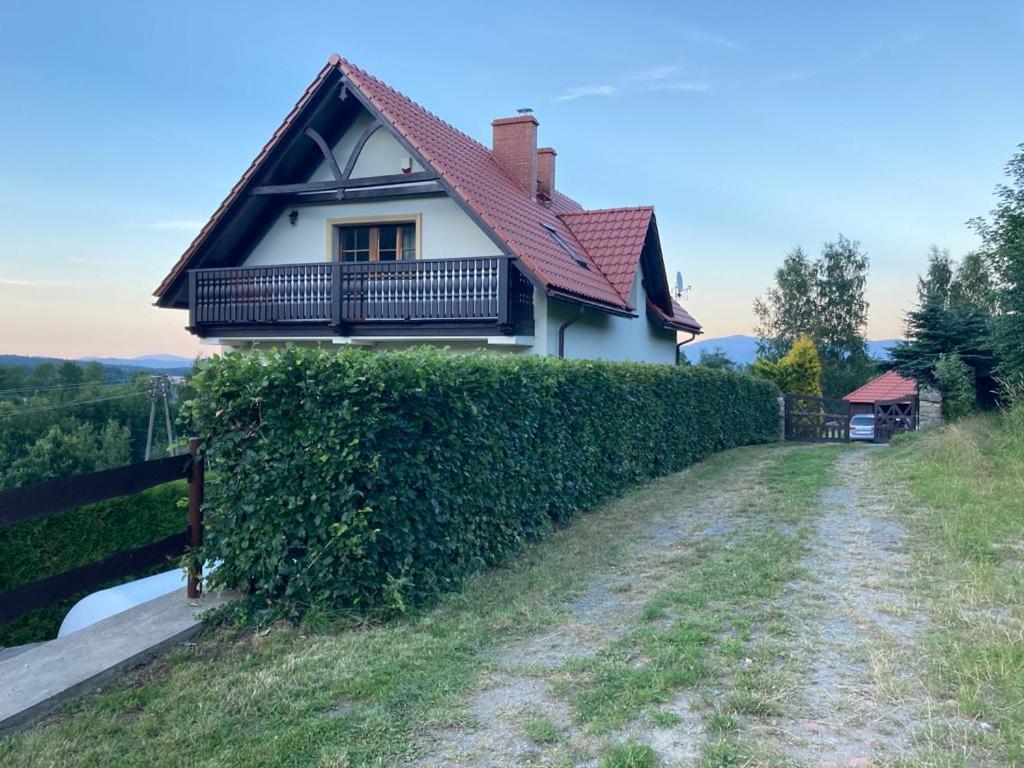 una casa en una colina junto a un seto en Domek całoroczny Poręba, en Poręba