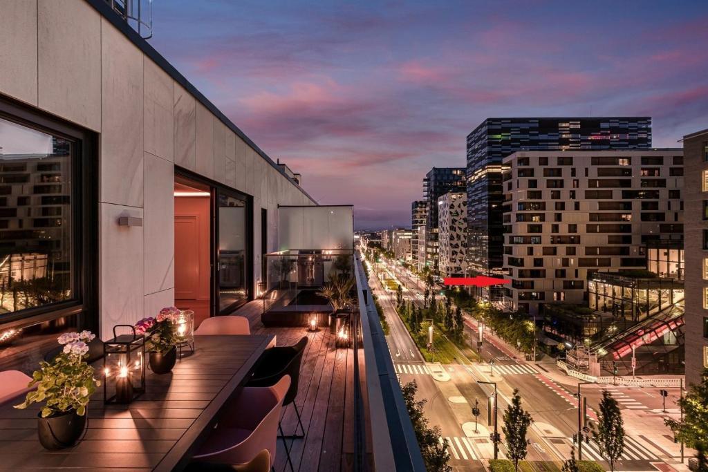 a balcony with a view of a city at night at Luxury 3BR apartment at CENTRAL OSLO barcode in Oslo