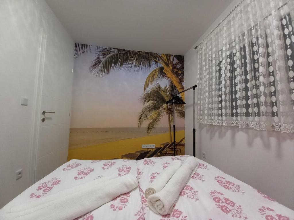 a bedroom with a bed with a palm tree mural at Sweet home in Brčko