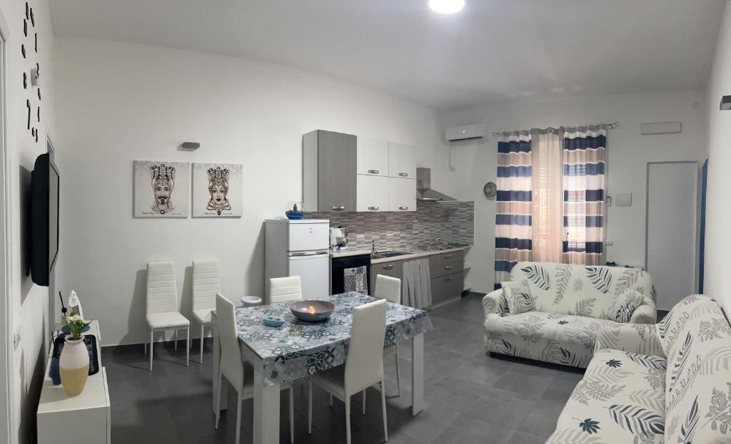 a kitchen and living room with a table and chairs at Sweet House Sicily in Terrasini
