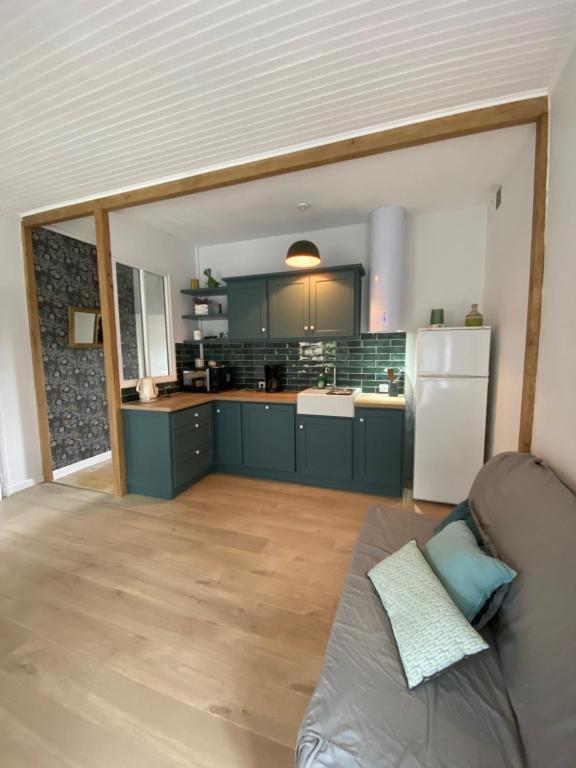 a kitchen with blue cabinets and a white refrigerator at La maison de Marie in Junhac