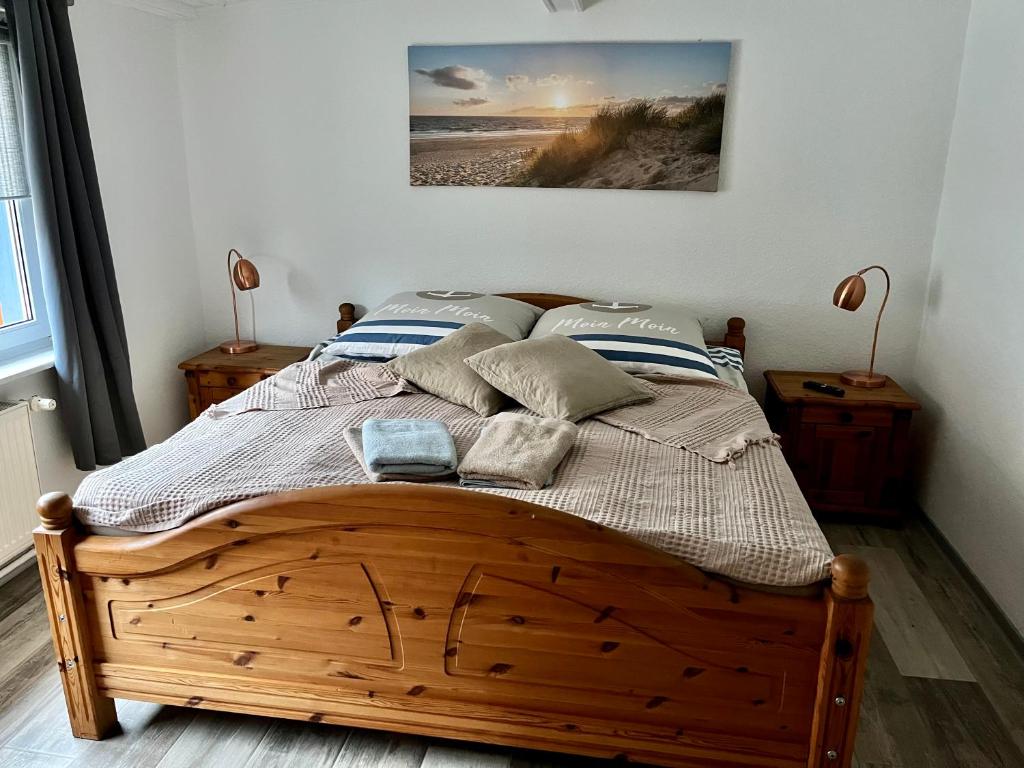 a bedroom with a wooden bed with a picture on the wall at Ferienhaus Ankerplatz in Lambrechtshagen