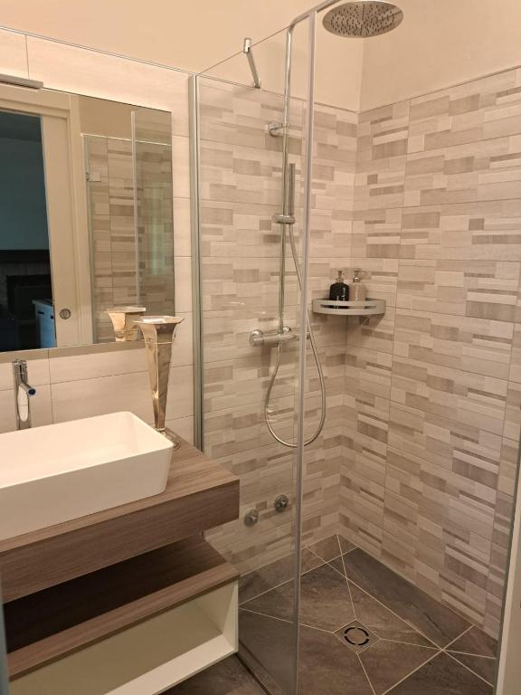 łazienka z umywalką i przeszkloną kabiną prysznicową w obiekcie LA CASA DI TALIN w mieście Serravalle delle Langhe