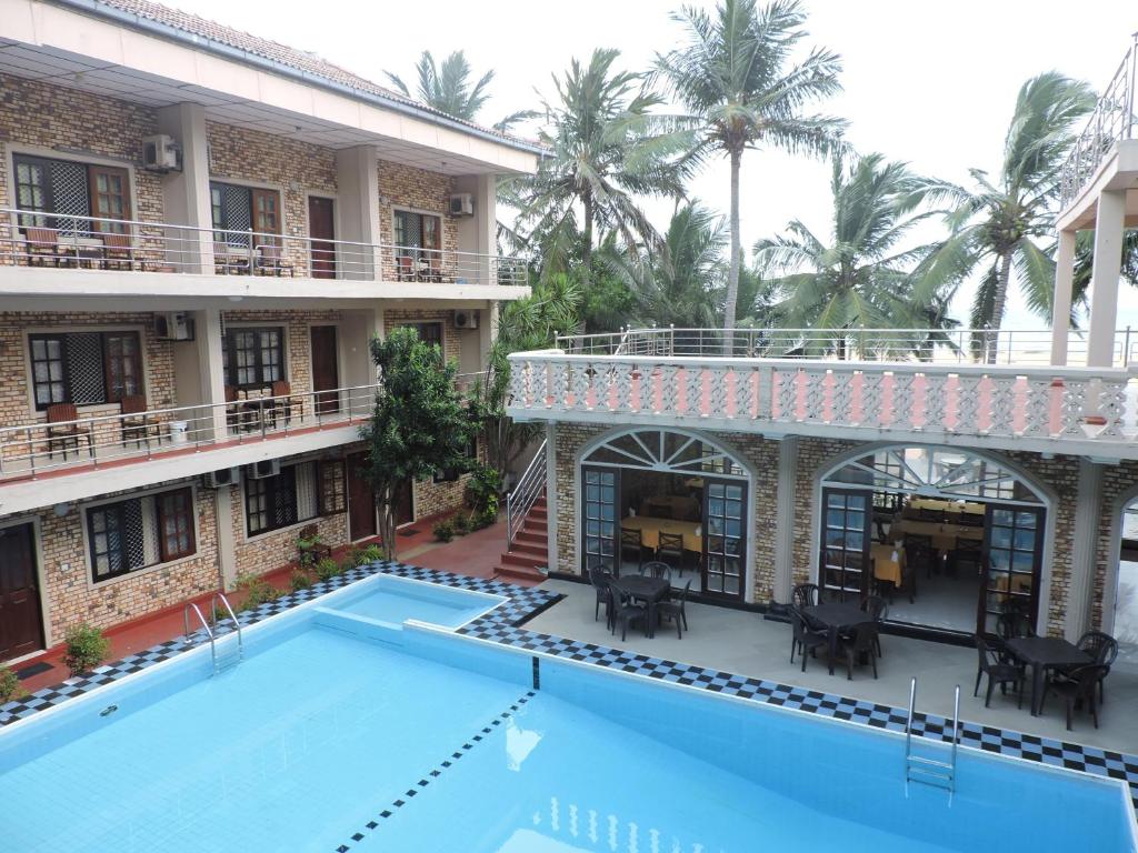 uitzicht op de binnenplaats van een hotel met een zwembad bij Oasis Beach Resort in Negombo