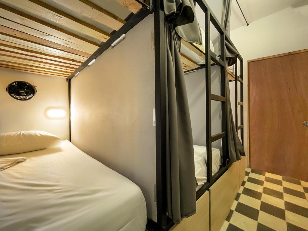 1 dormitorio con litera y suelo a cuadros en Baku Laureles Hostel en Medellín