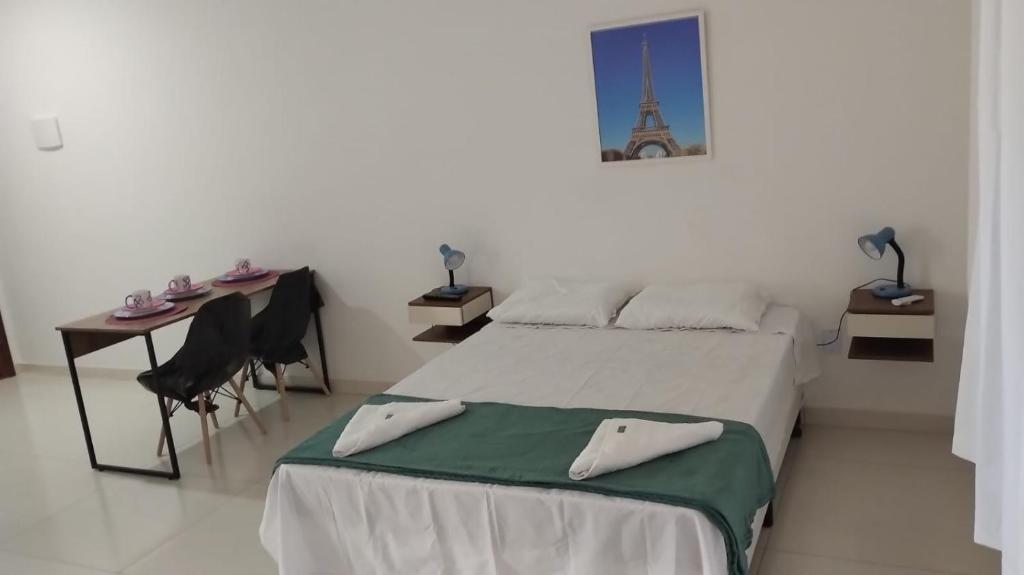 1 dormitorio con cama, mesa y escritorio en Loft PARIS para Casais, em Iguaba Grande, 150 metros da praia, en Iguaba Grande