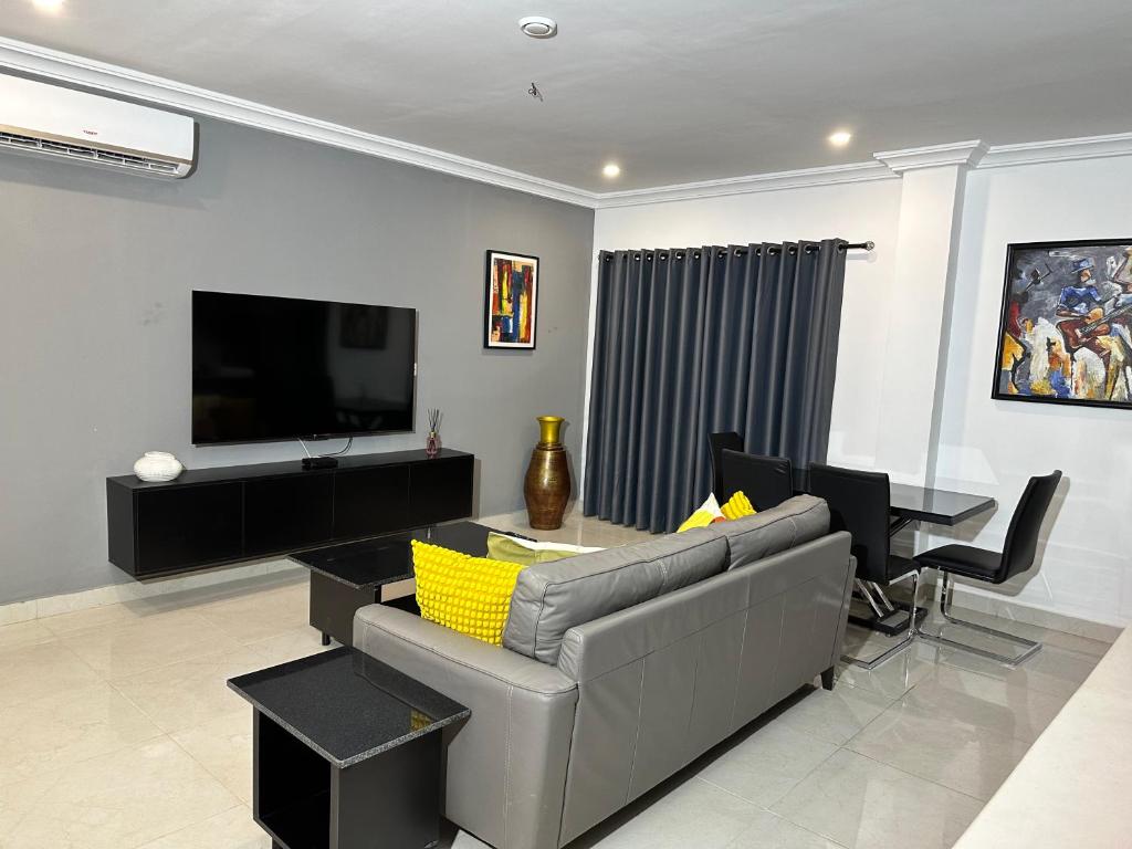 sala de estar con sofá, mesa y TV en Westlands Tower - Ghana Villas, en Accra