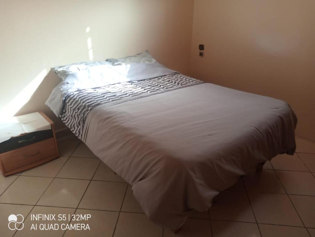 1 dormitorio con 1 cama grande con colcha blanca en شقة ببزنيقة, en Bouznika