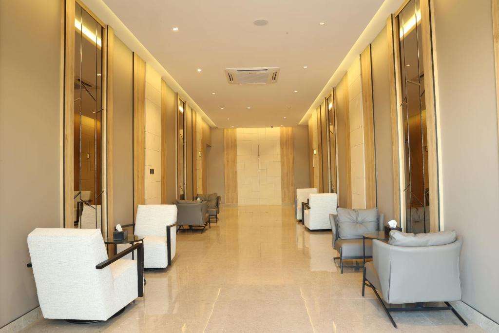 a hallway with white chairs and tables in a building at نيلوفر - Nilover in Tabuk