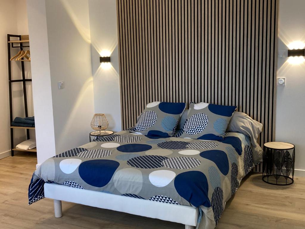 ein Schlafzimmer mit einem blauen und weißen Bett mit blauen Kissen in der Unterkunft Studio au couleur de l’océan in Riantec