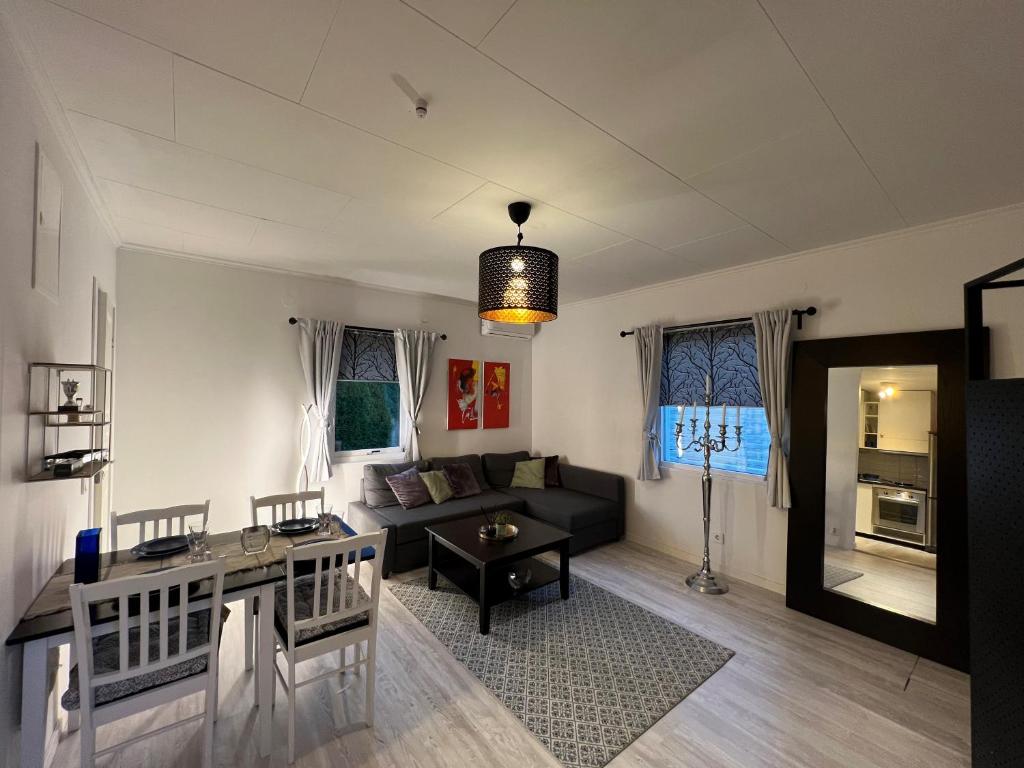 uma sala de estar com um sofá e uma mesa em Fresh And Cozy Little House 45km In Täby em Estocolmo
