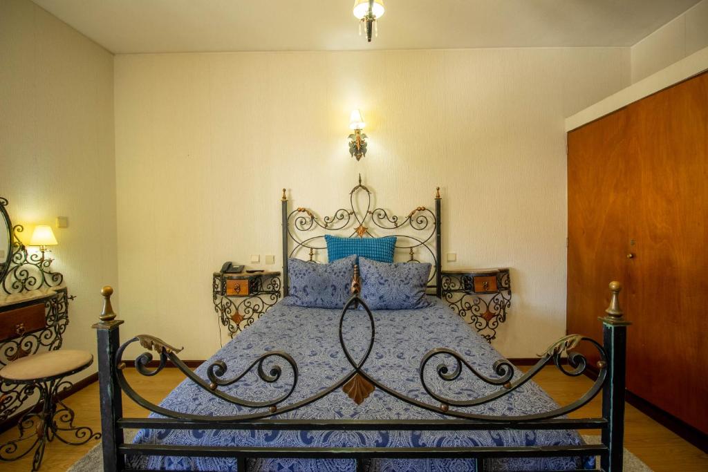 a bedroom with a large bed with blue pillows at Porto Je T'aime - Solar São João in São João da Madeira