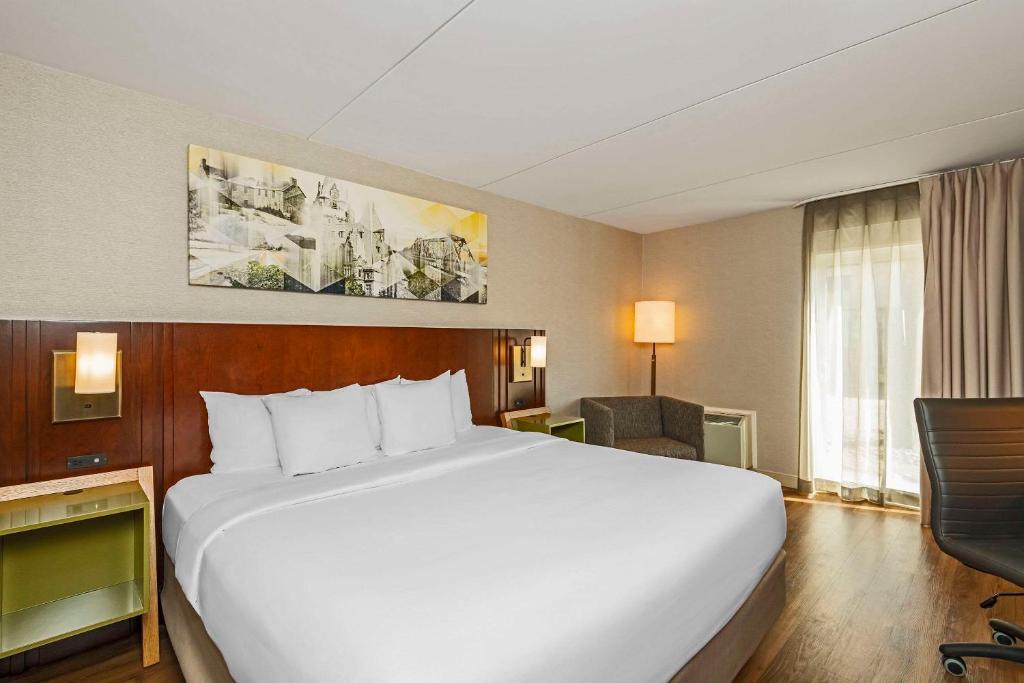 um quarto de hotel com uma cama grande e uma secretária em Comfort Inn Cambridge em Cambridge