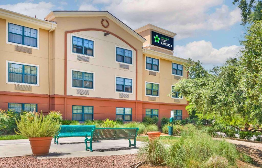 a building with two benches in front of it at Extended Stay America Suites - Los Angeles - Valencia in Stevenson Ranch