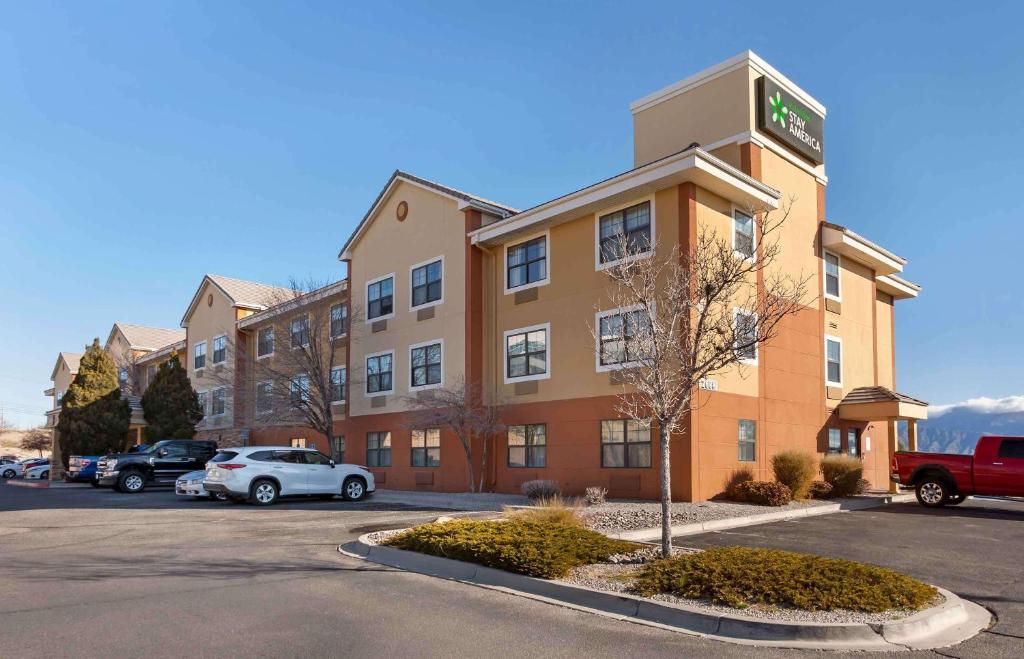 ein Apartmenthaus mit Autos auf einem Parkplatz in der Unterkunft Extended Stay America Suites - Albuquerque - Rio Rancho in Rio Rancho