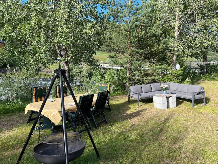 a table and chairs and a couch in a yard at Romslig hytte nær R7, Ål sentrum, fjell & skianlegg in Liagardane