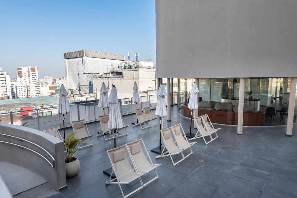 un balcone con sedie e ombrelloni in un edificio di VNF FREI CANECA a San Paolo