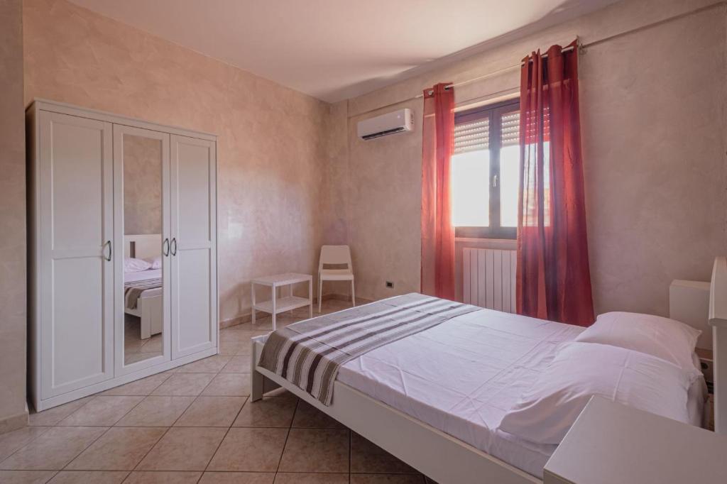 um quarto com uma cama e uma janela em Alloggio Alfa em Civitavecchia
