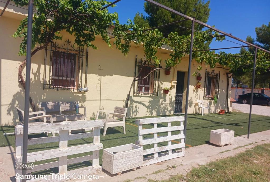 casa rural el mirador في Granja Arenales: منزل أمامه طاولة وكراسي للتنزه
