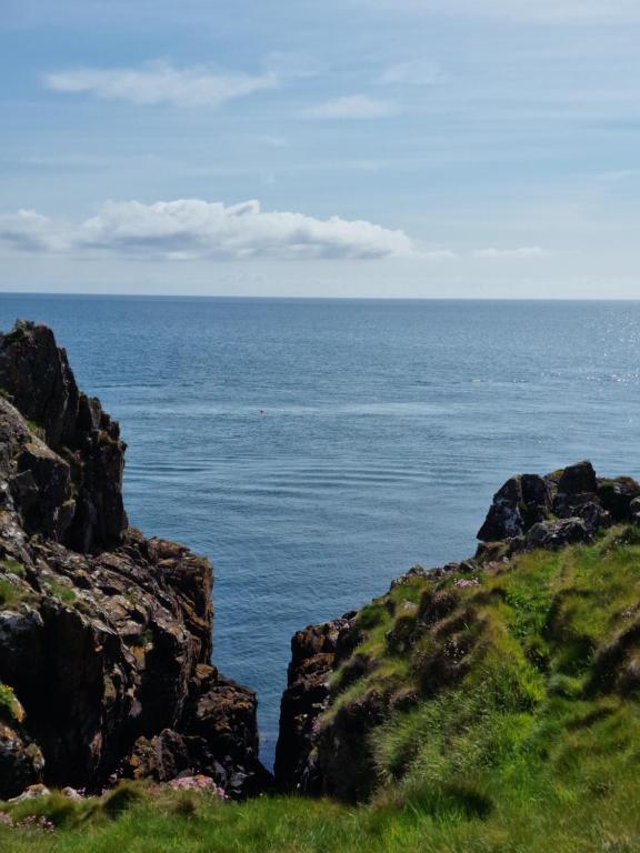 a view of the ocean from a hill with rocks at Stunning Holiday Home Whithorn3 in Newton Stewart