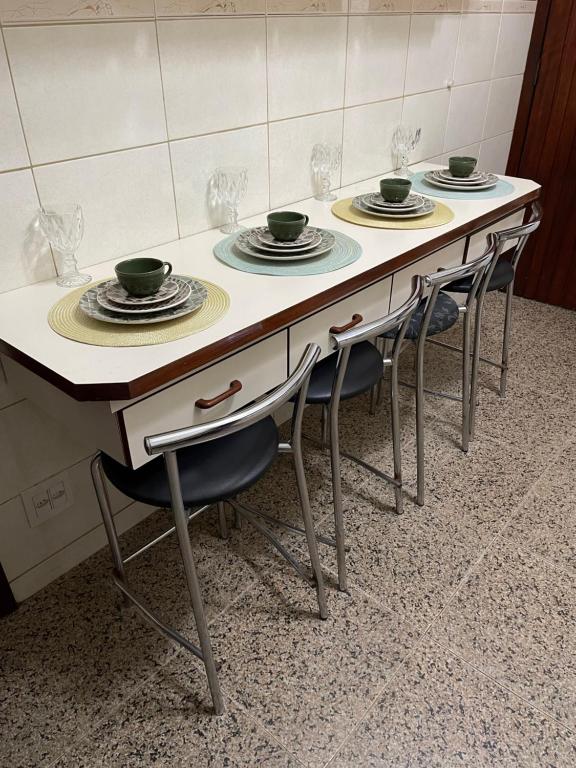 a table with four chairs and plates on it at Lindo quarto próximo ao metrô ! in Sao Paulo