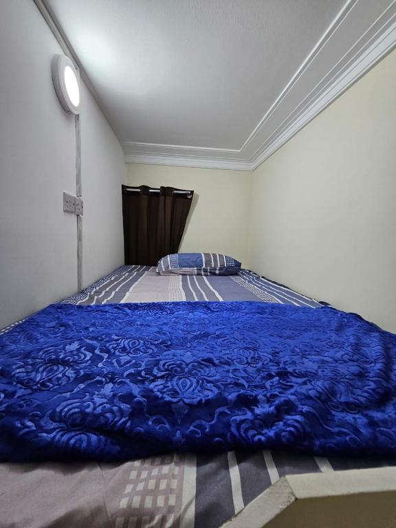 a bedroom with a blue blanket on a bed at SKY 9 Hostel in Dubai