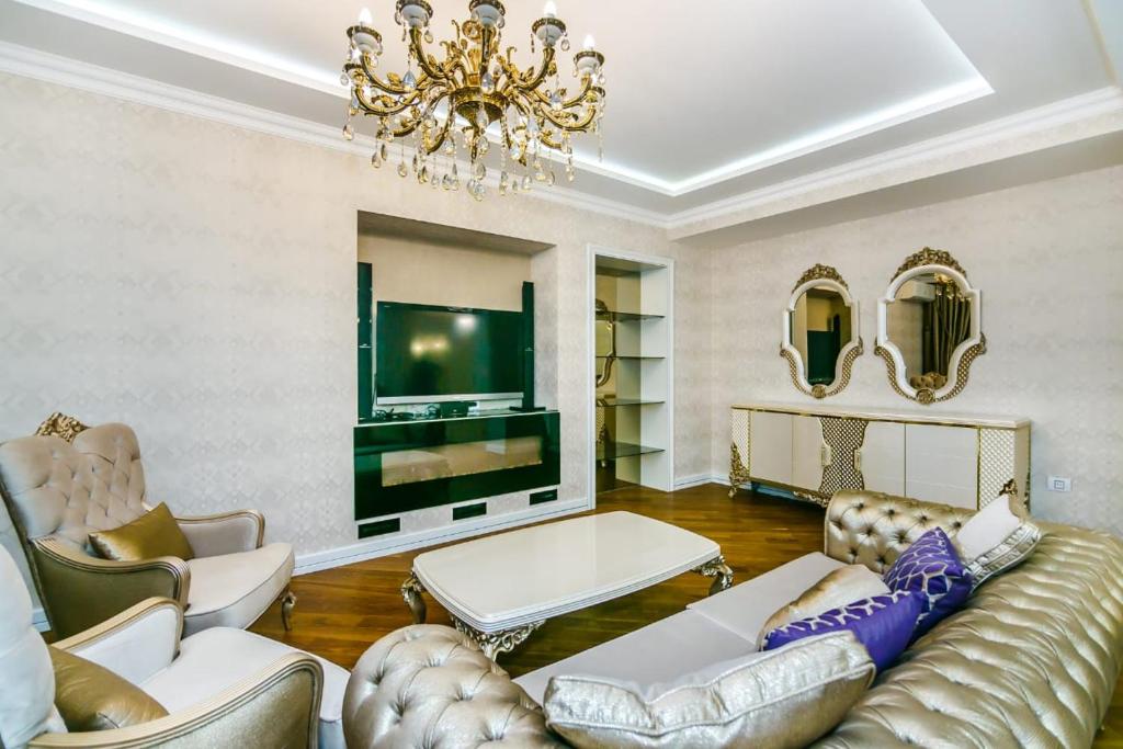 a living room with a couch and a tv at Nizami Street VIP Apartment in Baku