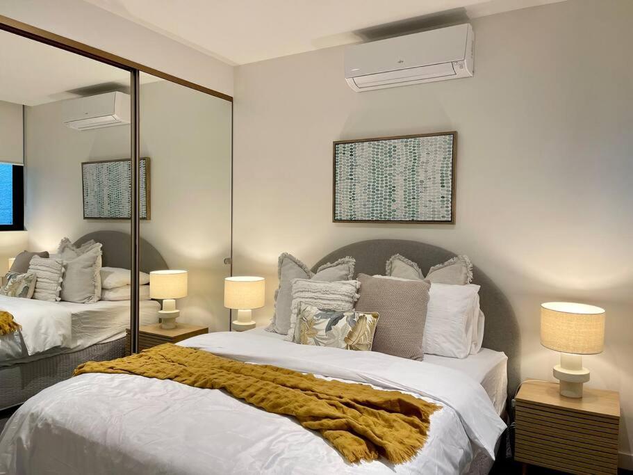 een slaapkamer met 2 bedden en een grote spiegel bij Modern 2 Bedrooms FREE Carpark in Melbourne