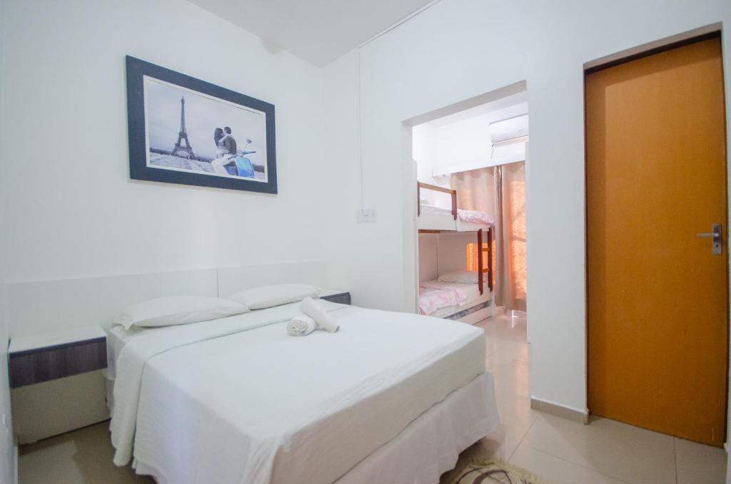 a white bedroom with a bed and a picture on the wall at Hotel Penha in Penha