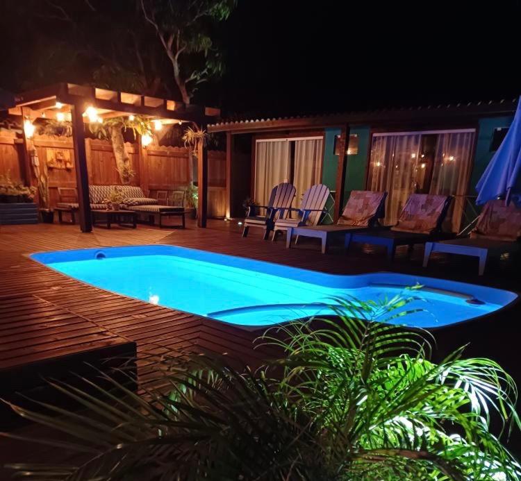 uma piscina à noite com cadeiras e uma mesa em Pousada Inn Nature em Palhoça