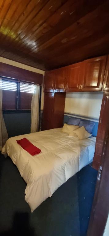 a bed with a red blanket on top of it at Casa Gelsi - El Cadillal in Tafí Viejo
