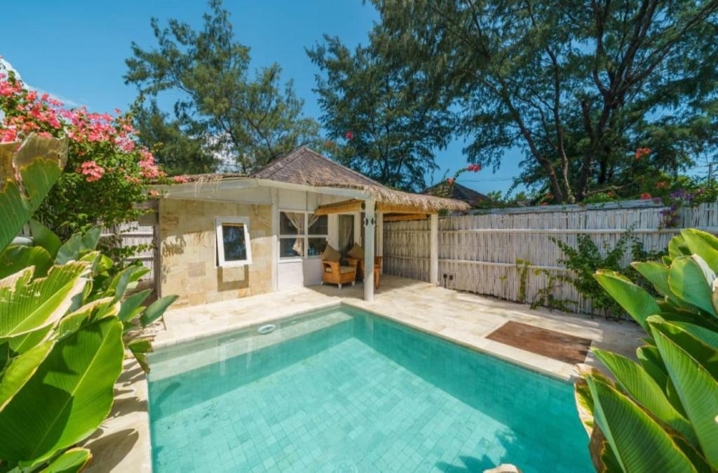 a swimming pool in front of a house at Ora Villas Gili Meno in Gili Meno