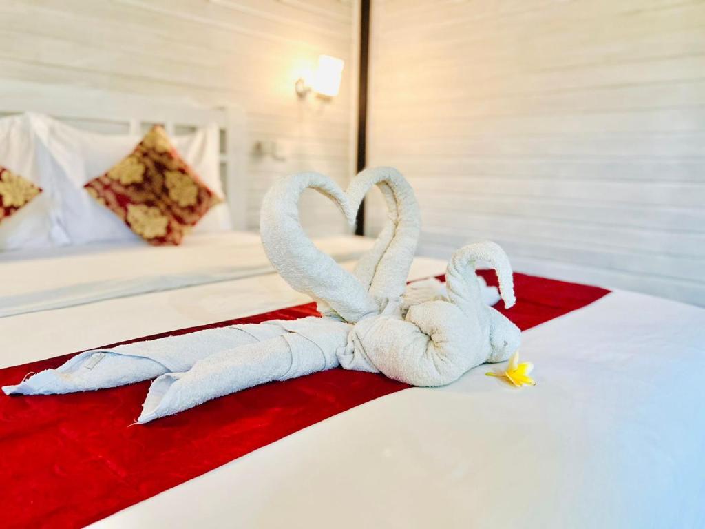 two swans made out of towels on a bed at Tarci Bungalows Lembongan in Nusa Lembongan