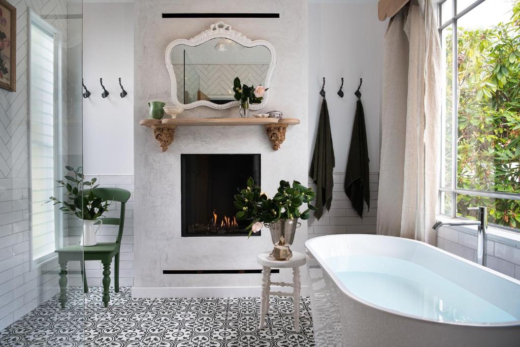 a bathroom with a tub and a fireplace at Innisfree in Daylesford