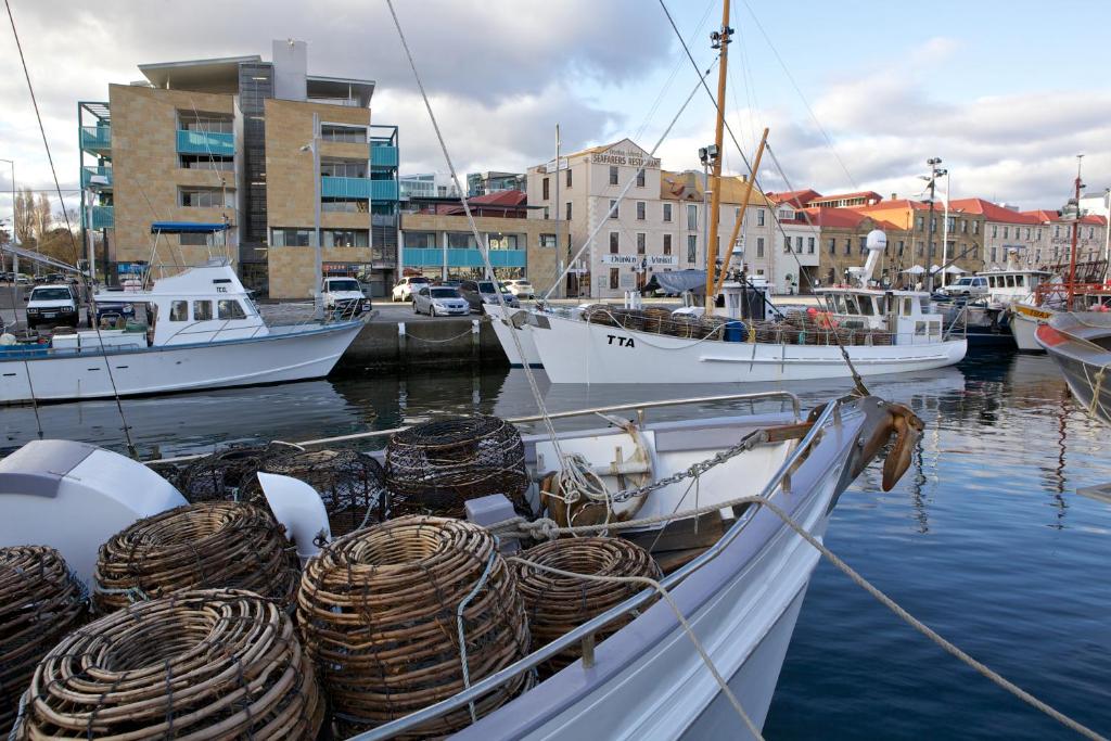 a boat is docked in a harbor with other boats at Zero Davey Boutique Apartment Hotel in Hobart