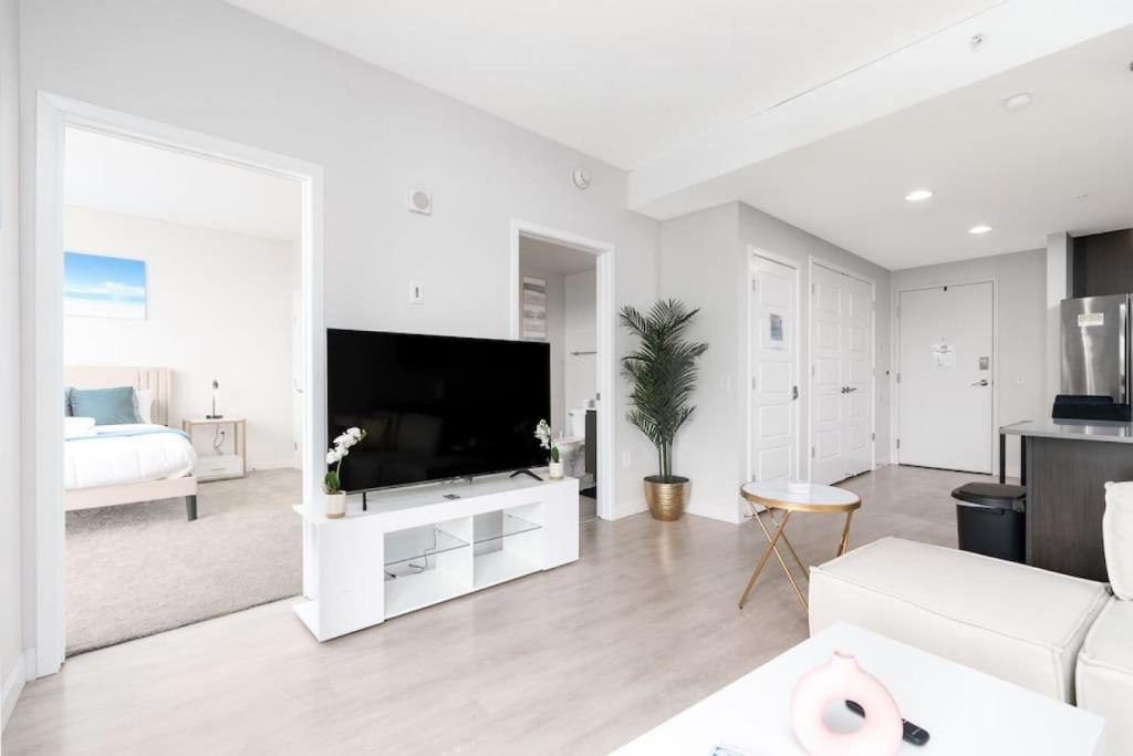 a white living room with a television and a bed at Indy Monument Circle Apt in Indianapolis