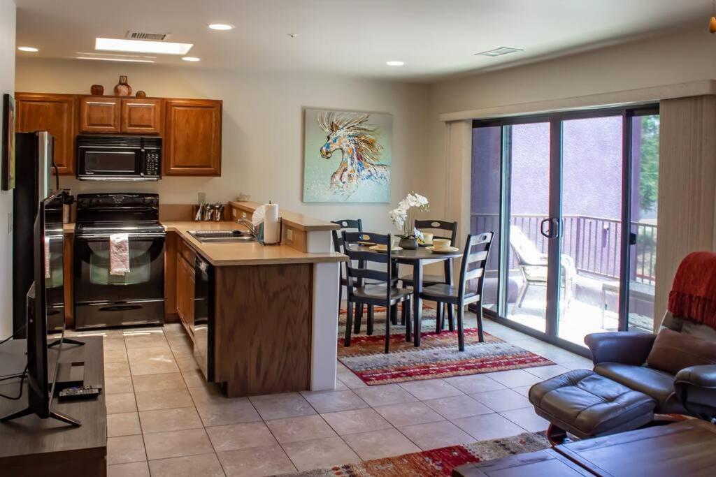 a kitchen and living room with a table and chairs at Carnelian Coyote - Fabulous Condo in West Sedona! in Sedona