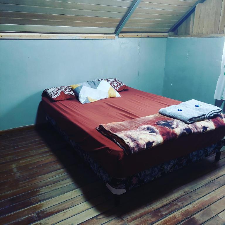 una camera da letto con letto con lenzuola e cuscini rossi di Bambito Hosting a Bambito
