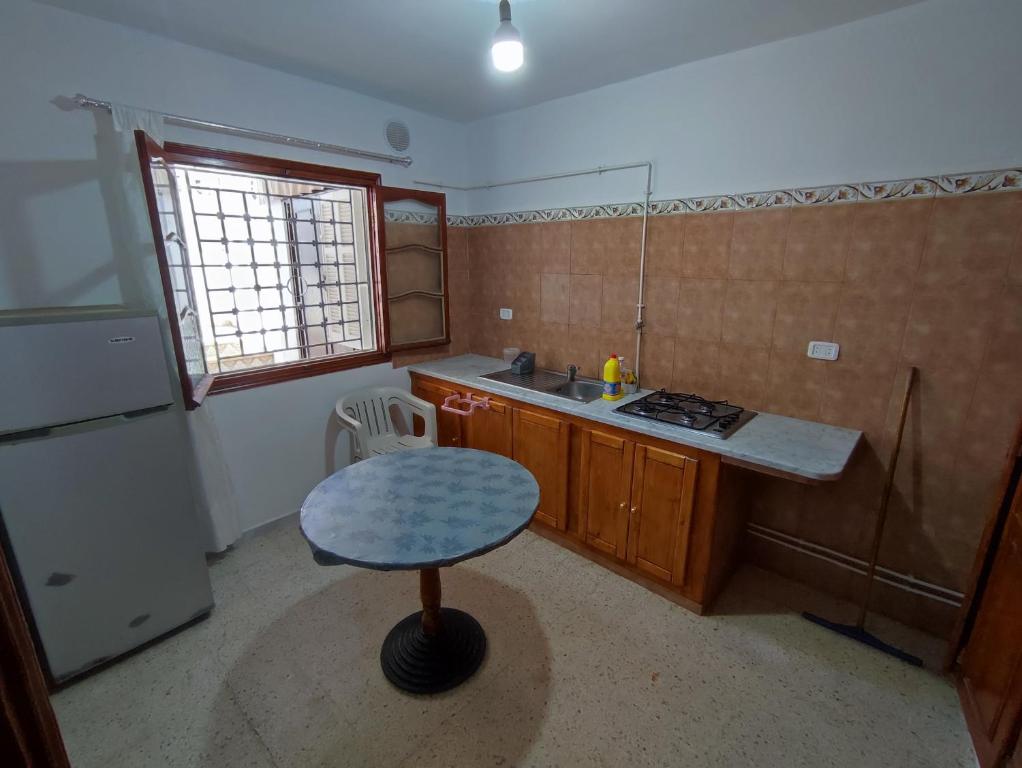 a small kitchen with a table and a sink at Calm place and near to the beach in Monastir
