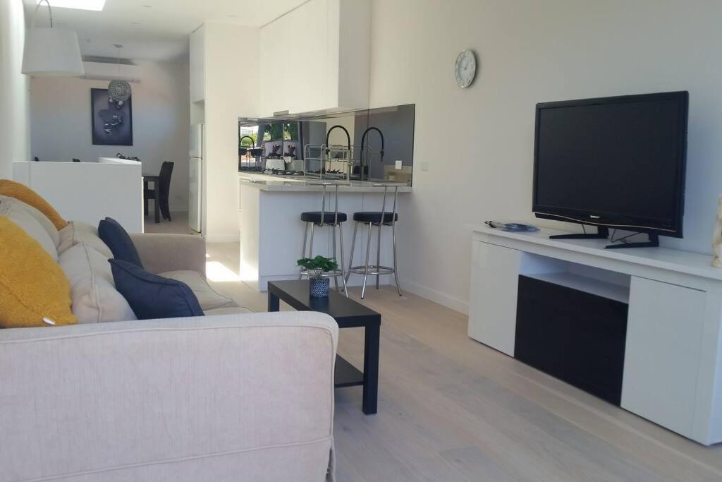 a living room with a couch and a flat screen tv at 3 BDR Townhouse 200m from station 4 beds in Melbourne