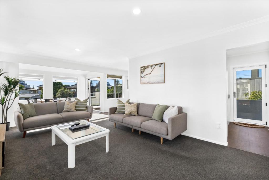 a living room with two couches and a coffee table at Idyllic family escape, Close to the beach and Mount in Mount Maunganui