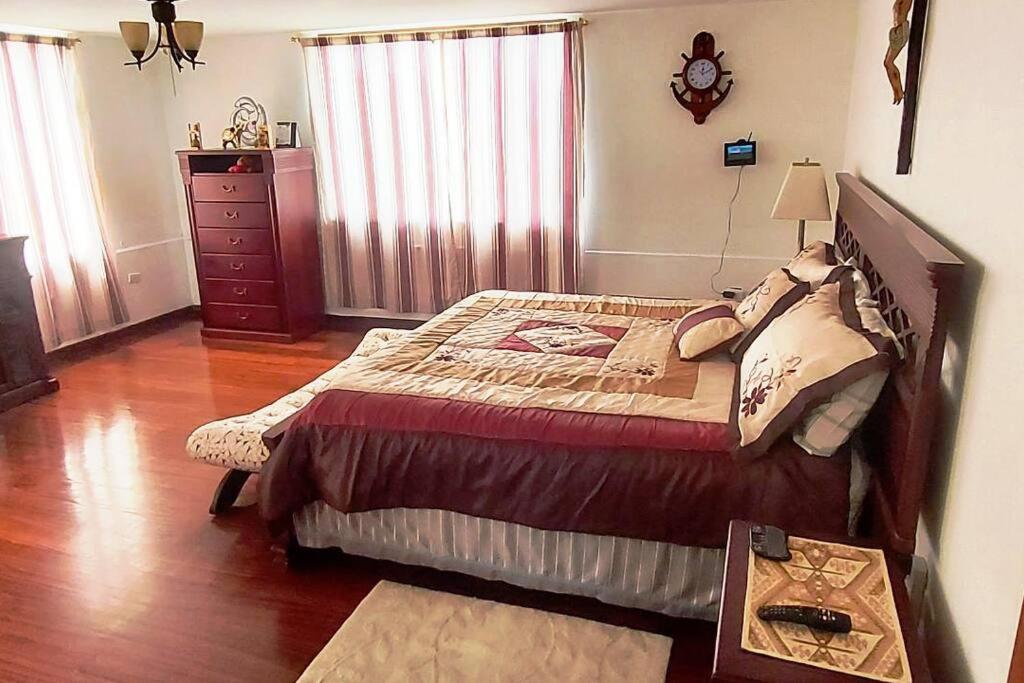 a bedroom with a large bed and a dresser at Suite grande, lujosa, en casa particular, jacuzzi in Riobamba