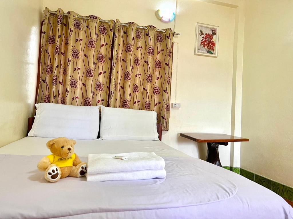 Khong Chiam Hotel في خونغ شيام: وجود دبدوب يجلس فوق السرير
