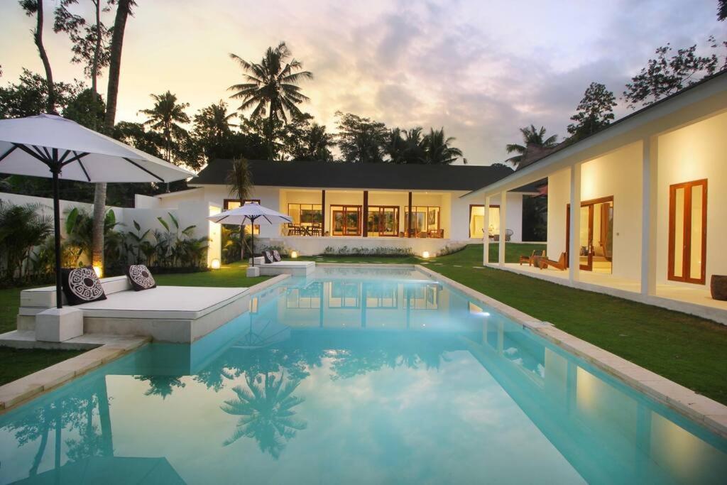 uma casa com piscina em frente a uma casa em Modern and stylish 3 Bedroom Villa em Ubud