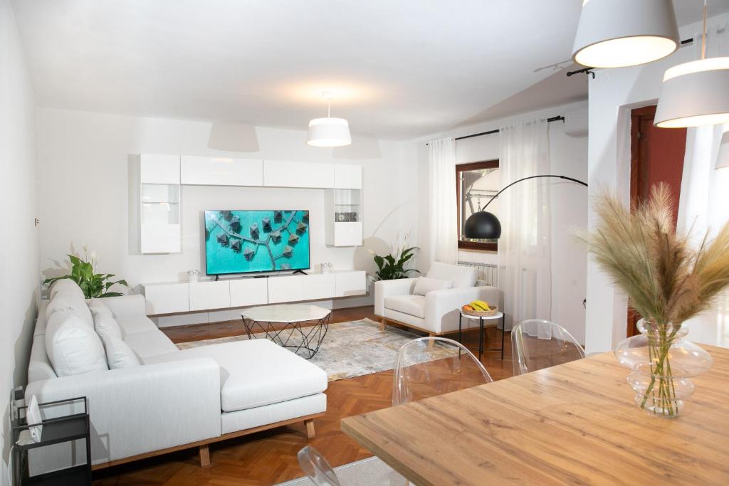 a living room with white furniture and a table at Apartment "Istra Inspirita II" in Rovinj