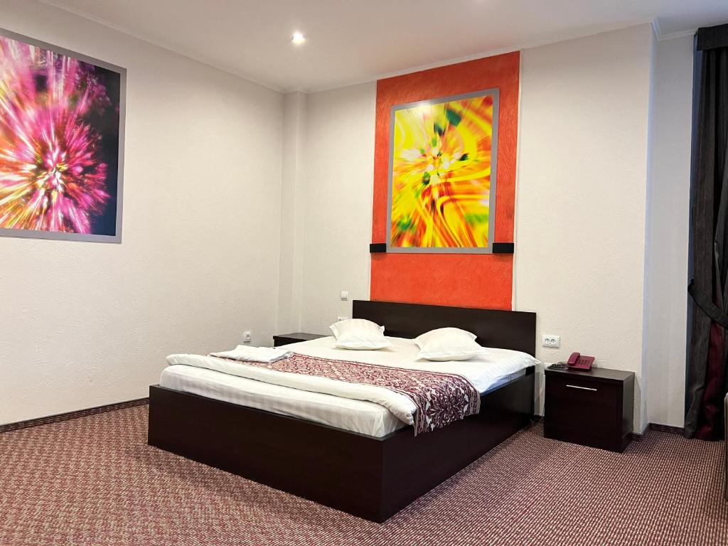 a bedroom with a bed and a painting on the wall at JEPPESEN RESIDENCE in Almaty