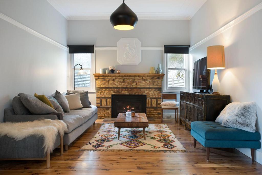 a living room with a couch and a fireplace at The Arlow House in Daylesford